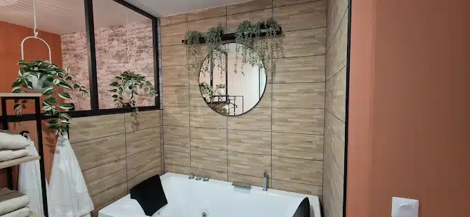 Salle de bains rénovée avec baignoire encastrée et mur effet bois à Rouen.