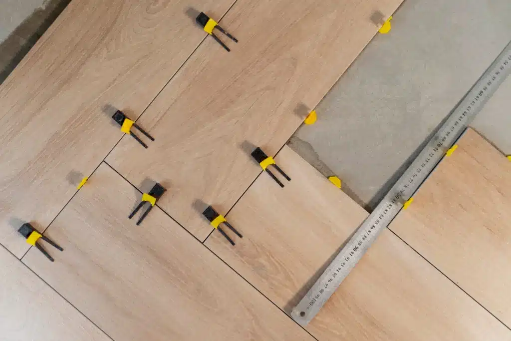 Pose de parquet avec croisillons et règle de précision à Rouen.