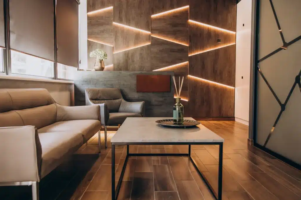 Salon moderne avec éclairage mural et parquet bois à Rouen.