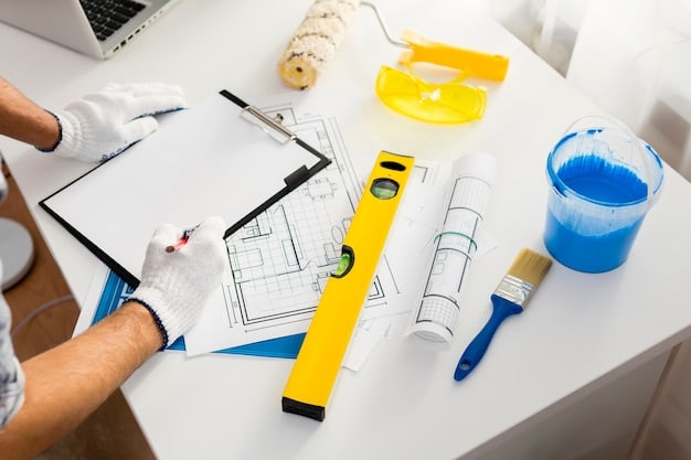 Plan de rénovation avec outils de chantier posés sur une table de travail.